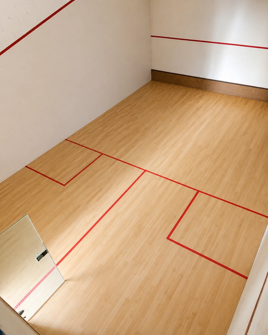 Freshly sanded squash court floor with red court lines